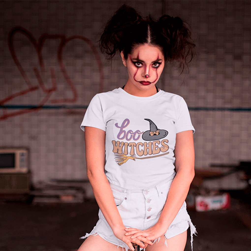 Person wearing a 'Boo Witches' t-shirt in an indoor setting with graffiti on the wall.