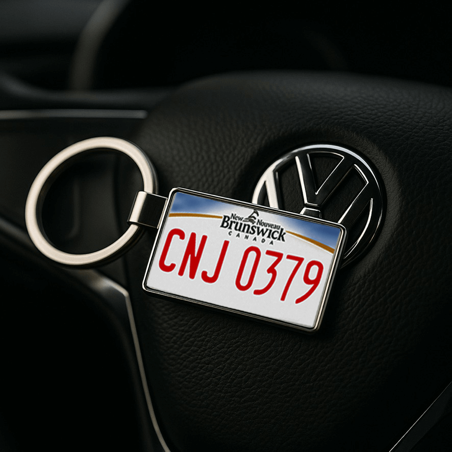 A New Brunswick-themed license plate keychain with the code 'CNJ 0379' placed on a black leather steering wheel featuring the Volkswagen logo. This sleek automotive scene highlights the keychain as a stylish and personal car accessory for Canadian travel fans. Made by Your iDeas Shop.