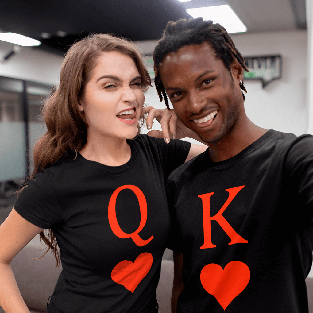 Two people wearing black t-shirts with 'QK' and red hearts, posing indoors.