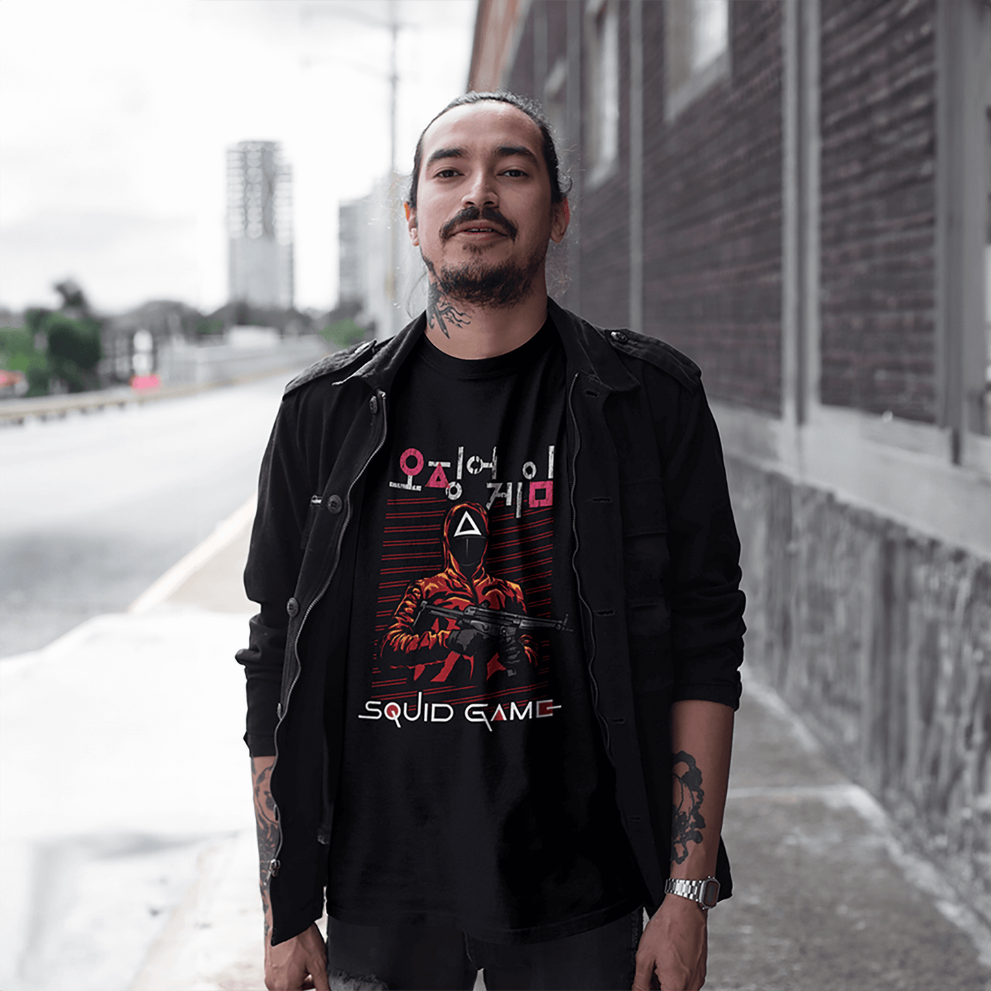 A fashionable man wearing a black jacket layered over a 'Squid Game' T-shirt, featuring the series' iconic masked guard graphic, walking along a modern street. A blend of street and pop culture style. Made by Your iDeas Shop
