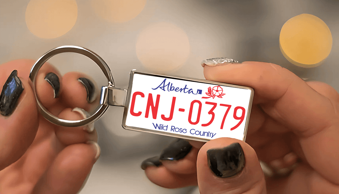 A metal keychain featuring a miniature replica of an Alberta license plate with red text 'CNJ-0379' and the phrase 'Wild Rose Country'. A stylish and personalized accessory for car enthusiasts. Made by Your iDeas Shop.