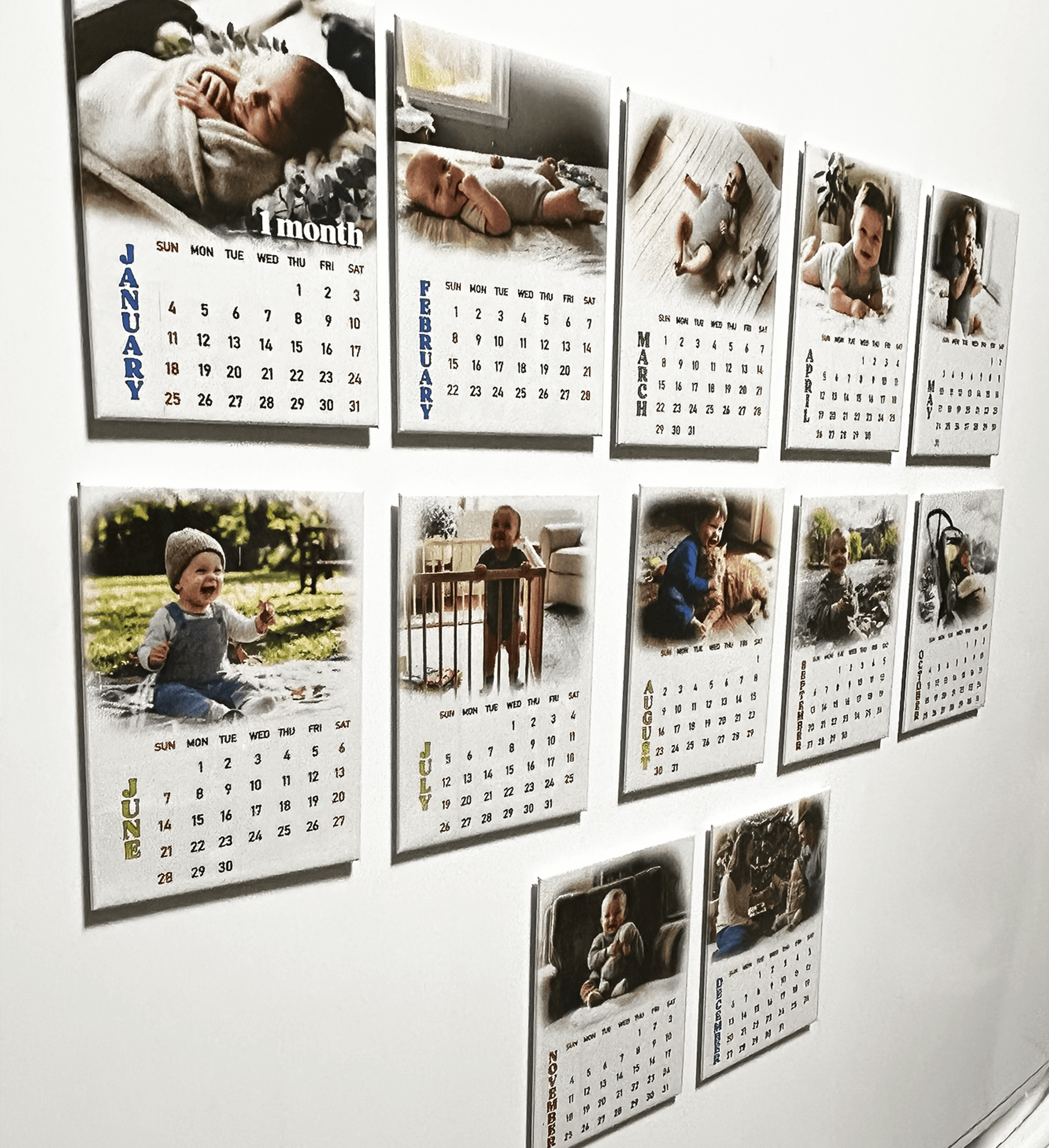 Personalized 12-month photo magnet calendar set showcasing baby photos and monthly calendars on a wall.