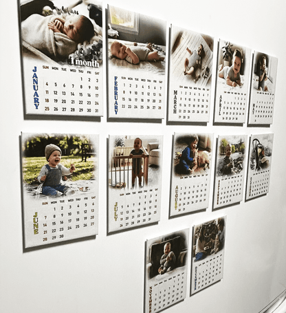 Personalized 12-month photo magnet calendar set showcasing baby photos and monthly calendars on a wall.