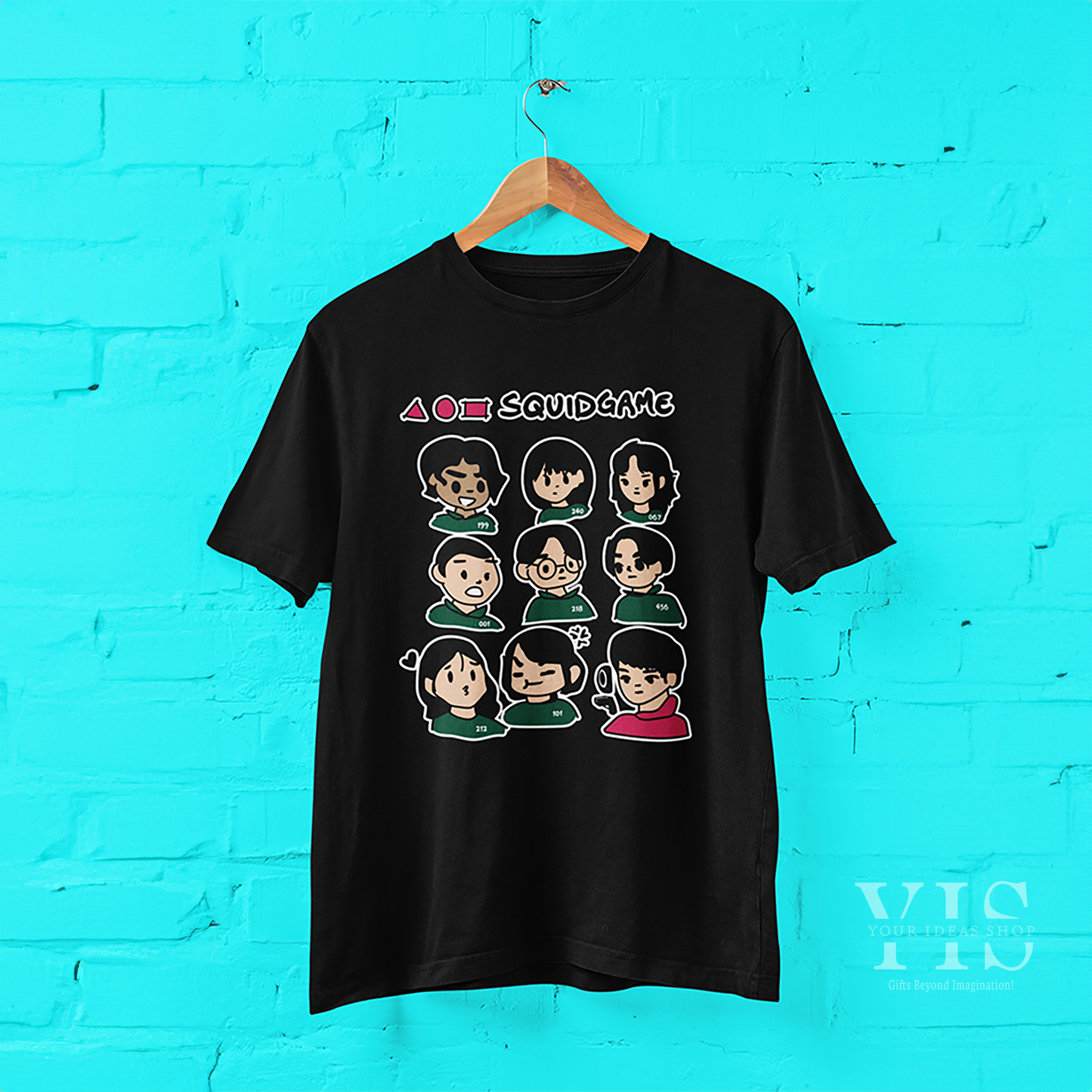 A black T-shirt hanging on display, featuring a fun, cartoonish Squid Game design. The layout includes a grid of character faces, bold shapes, and the series title in striking colors. A great addition to any fan's wardrobe. Made by Your iDeas Shop