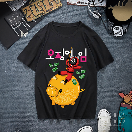A black T-shirt featuring a cartoon graphic inspired by Korean pop culture. The design includes a bright yellow piggy bank filled with money, with a character in a red jumpsuit holding a staff and climbing the piggy bank. Ideal for fans of unique and trendy apparel. Made by Your iDeas Shop.