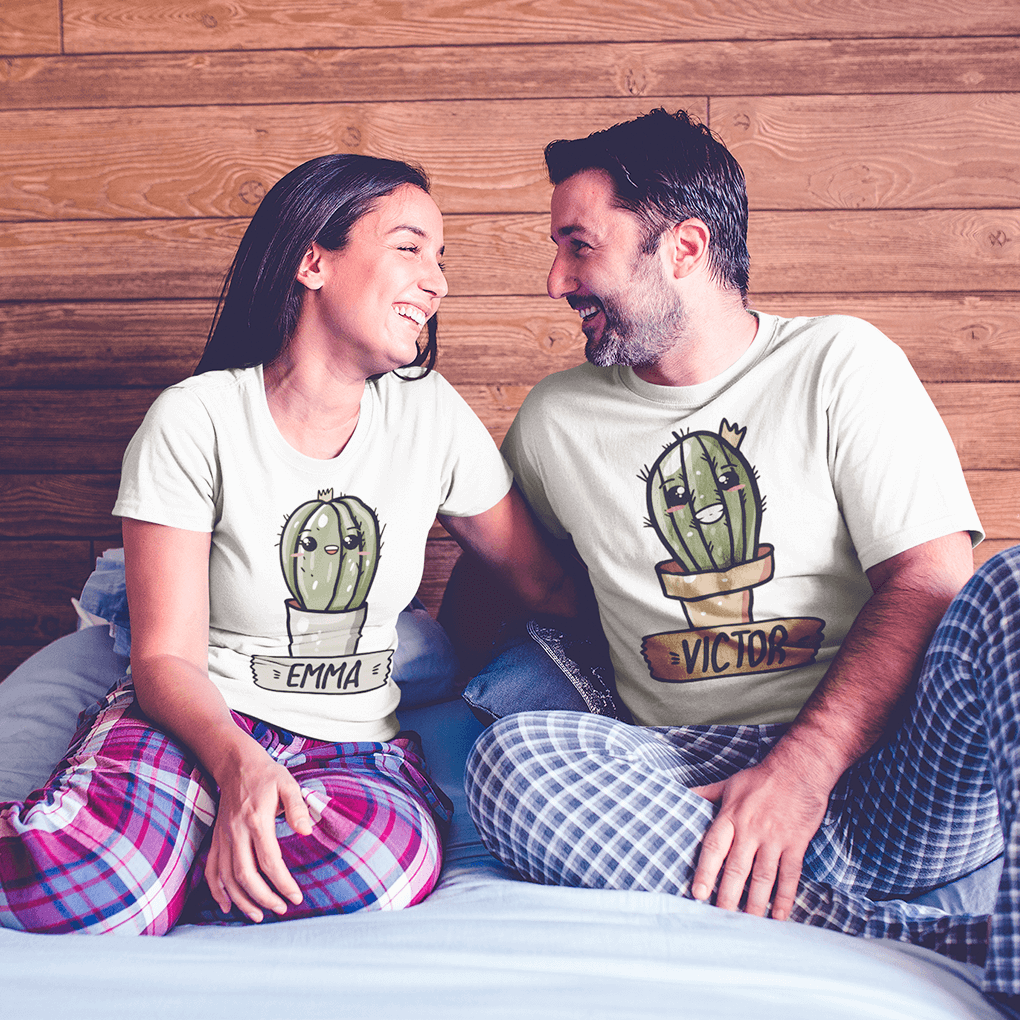 Two people sitting on a bed wearing matching t-shirts with cactus designs and names.