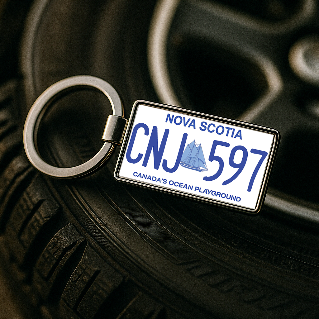 A metal keychain shaped like a Nova Scotia license plate with the number CNJ 597, placed on a car tire with a wheel rim in the background. Perfect for car enthusiasts or as a unique automotive gift. Made by Your iDeas Shop.