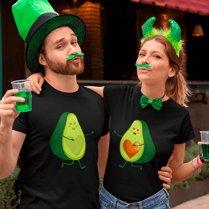 Two people wearing black t-shirts with avocado designs, green hats, and holding drinks.