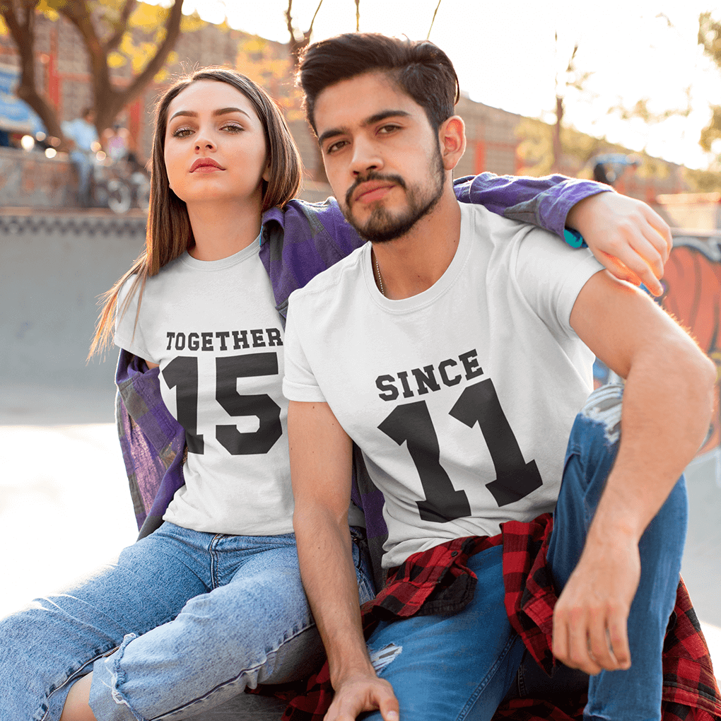 Man and woman with 'MRS.' shirt holding red roses against a purple background