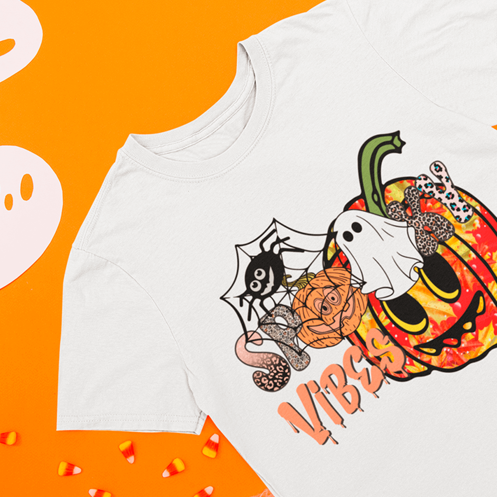 White t-shirt with Halloween-themed design on an orange background