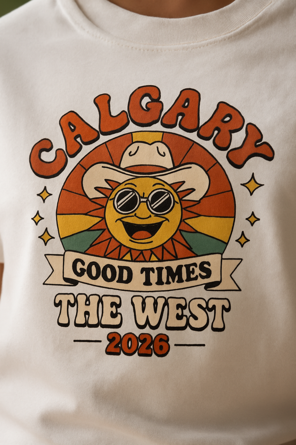 Calgary Good Times 2026 print close-up — retro groovy smiling sun in cowboy hat on white cotton, CALGARY GOOD TIMES THE WEST 2026